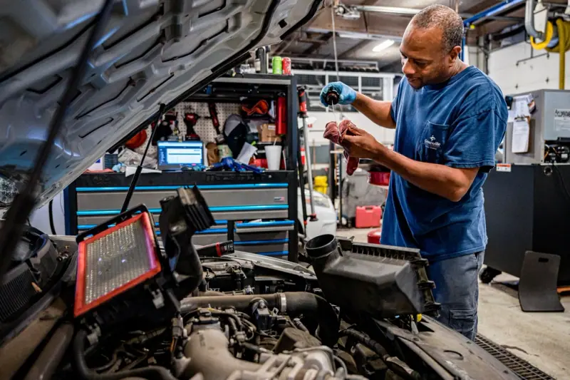 Technicien effectuant un diagnostic électronique sur un véhicule